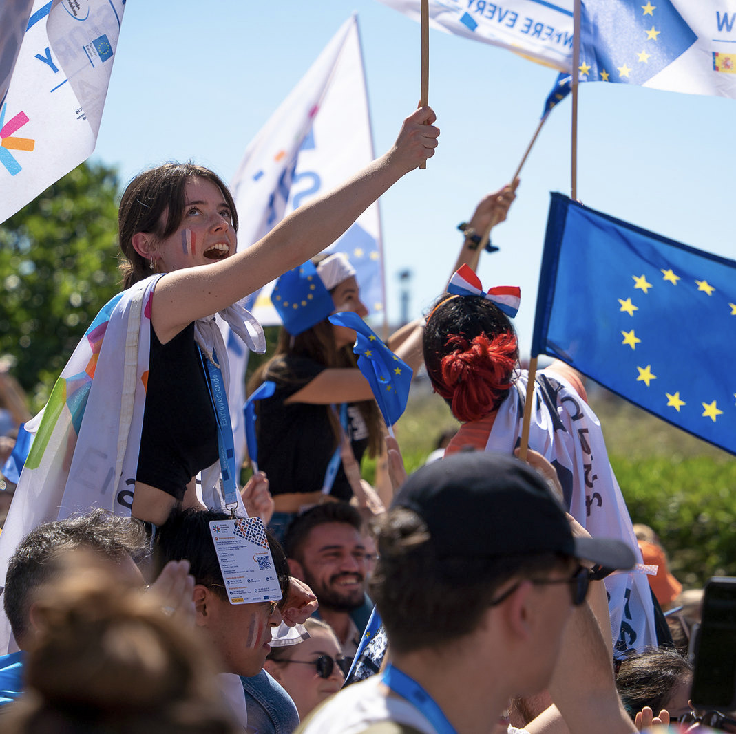 Image of a people outside holding flags.